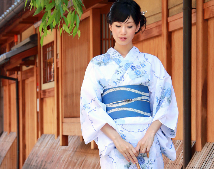 Девушка японка в бело-голубом юката с цветочным орнаментом и синим хан-оби